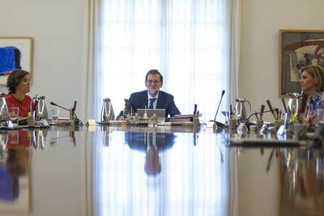 Spain's Prime Minister Mariano Rajoy, centre, attends an urgent cabinet meeting at the Moncloa palace in Madrid. (AP Photo/Francisco Seco)