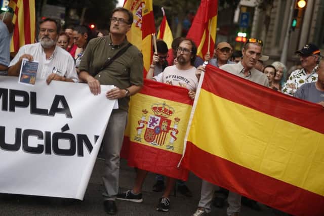 People hold Spanish flags and a banner during a demonstration organised by the Spanish right-wing party Vox in front of the Spain Government Delegation in Barcelona. Picture: Getty Images