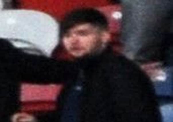 Police have issued an image of a man they want to trace after a football player was hit by a coin during a match.