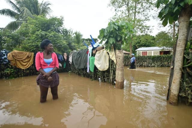 Marie Charlotte walks through water near her house that was flooded, in Malfeti, in the city of Fort Liberte, in the north east of Haiti, on September 8, 2017, during the passage of Hurricane Irma. Irma has been downgraded to a Category Four hurricane but is still extremely dangerous, the National Hurricane Center said. / AFP PHOTO / HECTOR RETAMALHECTOR RETAMAL/AFP/Getty Images