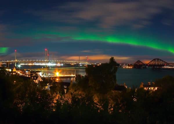 The three Bridges of the Firth of Forth are framed by a bright green aurora. Picture: SWNS
