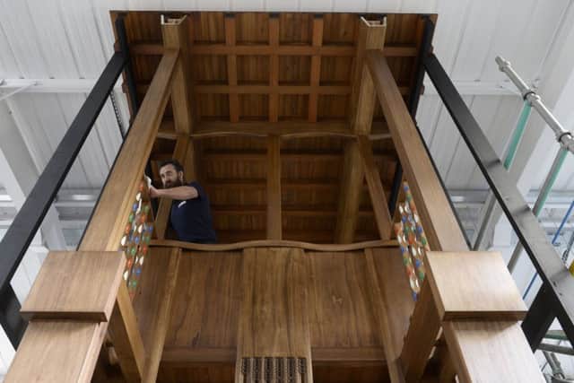 Master carpenter Angus Johnston with a full size Tulip wood prototype section of the 1910 Charles Rennie MacKintosh designed library. Picture: SWNS