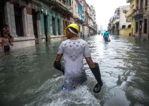 Cubans wade through a flooded street in Havana. Picture: YAMIL LAGE/AFP/Getty Images