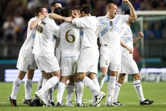 Scotland players swarm around goal hero James McFadden after netting the winner over France. Picture: SNS