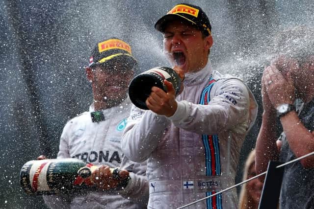 Valtteri Bottas celebrates on the podium after winning the Austrian Grand Prix. Lewis Hamilton, left, finished fourth. Picture: Dan Istitene/Getty Images