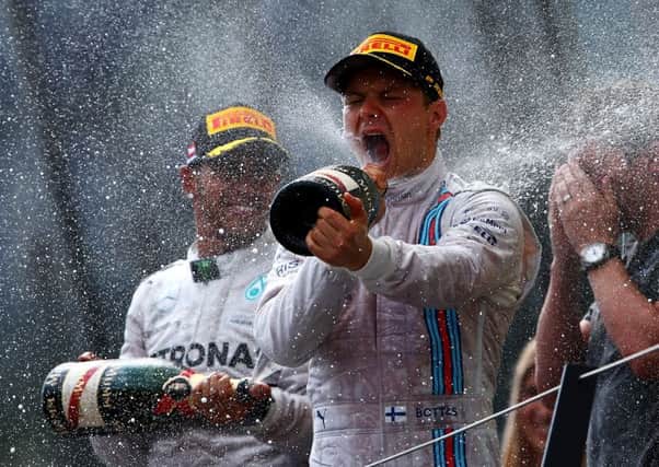 Valtteri Bottas celebrates on the podium after winning the Austrian Grand Prix. Lewis Hamilton, left, finished  fourth. Picture: Dan Istitene/Getty Images
