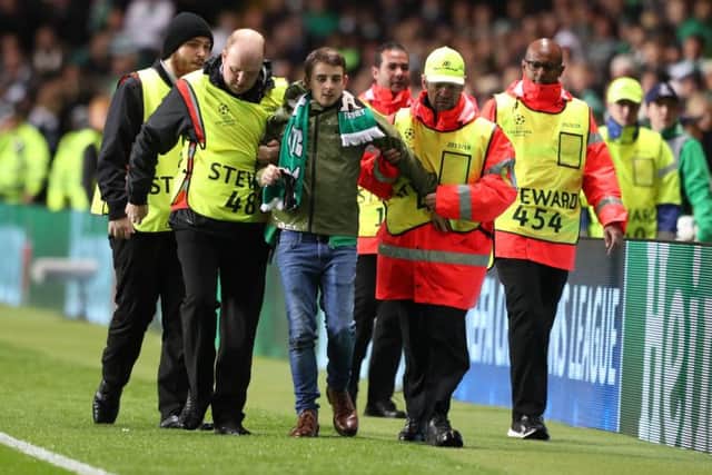 John Hatton is led away after running on the pitch during Celtic's Champions League match against Paris Saint-Germain. Picture: Andrew Milligan/PA Wire