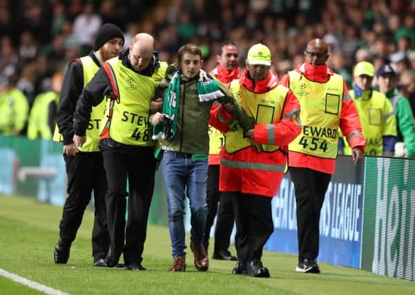 John Hatton is led away after running on the pitch during Celtic's Champions League match against Paris Saint-Germain. Picture: Andrew Milligan/PA Wire