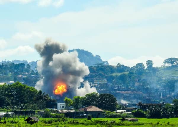 Smoke billows from houses after aerial bombings by Philippine Airforce planes on Islamist militant positions in Marawi. Picture: FERDINANDH CABRERA/AFP/Getty Images