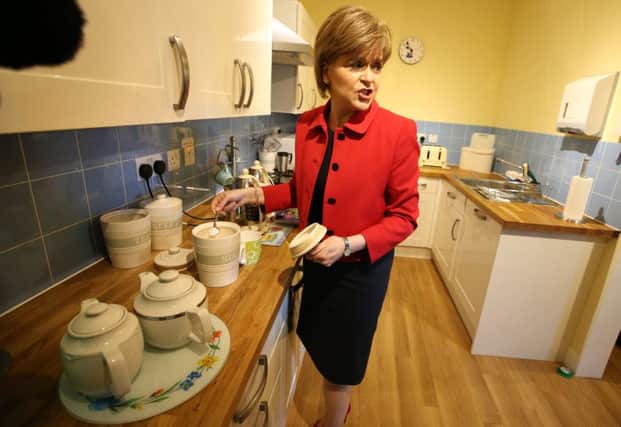 First Minister Nicola Sturgeon makes tea and coffee for staff and service users during a visit to St Joseph's Services in Rosewell, Scotland, which provides support to adults with learning disabilities.