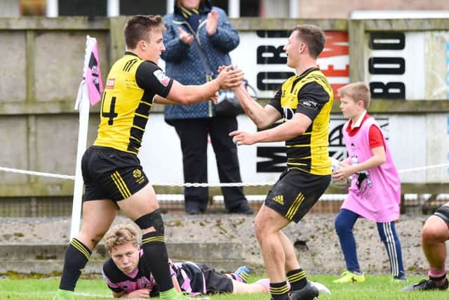 Melrose right-wing Ross McCann, left, celebrates one of his two tries before half-time. Picture: SNS.