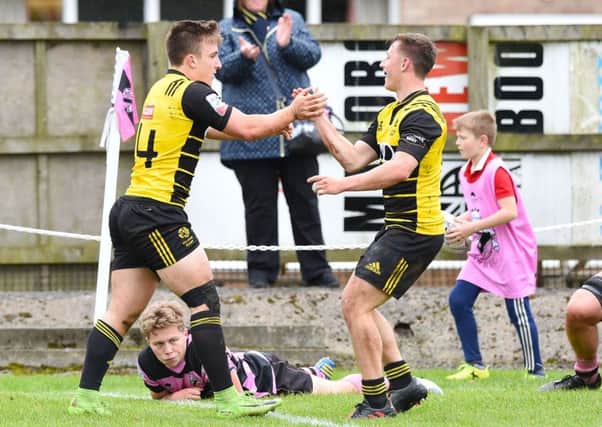 Melrose right-wing Ross McCann, left, celebrates one of his two tries before half-time. Picture: SNS.