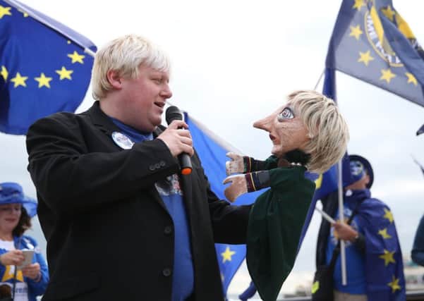 A Boris Johnson impersonator holds a Theresa May puppet during an Exit for Brexit rally during the second day of the Liberal Democrats Autumn Conference. Picture: Andrew Matthews/PA Wire