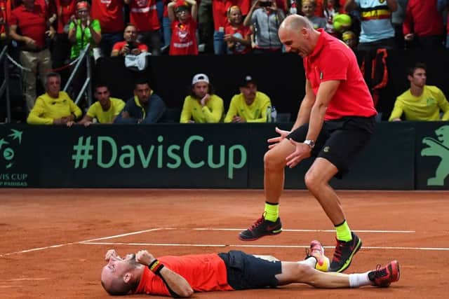 Belgiums Steve Darcis, left, and captain Johan Van Herck celebrate victory over Australia in the Davis Cup. Picture: Getty.