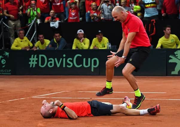 Belgiums Steve Darcis, left, and captain Johan Van Herck celebrate victory over Australia in the Davis Cup. Picture: Getty.