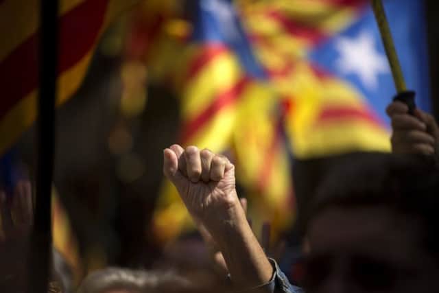 A pro Independence demonstrator gestures as Catalan mayors under investigation take part in a march. (AP Photo/Emilio Morenatti)