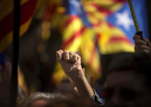 A pro Independence demonstrator gestures as Catalan mayors under investigation take part in a march. (AP Photo/Emilio Morenatti)