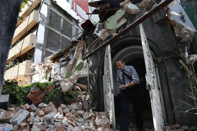 A man walks out of the door frame of a building that collapsed after an earthquake in the Condesa neighborhood of Mexico City. Picture: AP