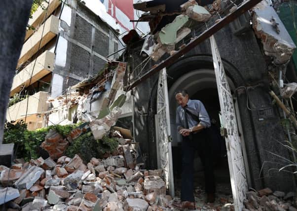 A man walks out of the door frame of a building that collapsed after an earthquake in the Condesa neighborhood of Mexico City. Picture: AP