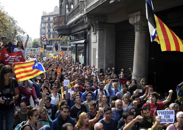 People holding 'Esteladas' flags protest during a police raid on offices of Catalonia's regional government. Picture: AFP/Getty Images