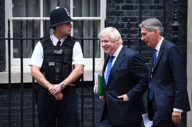 Britain's Foreign Secretary Boris Johnson (L) and Britain's Chancellor of the Exchequer Philip Hammond leave after a Cabinet meeting at 10 Downing Street in central London, on September 21, 2017. 
British ministers put on a show of unity as they met on the eve of Prime Minister Theresa May's major speech on Brexit, which has been overshadowed by cabinet divisions. / AFP PHOTO / Chris J RatcliffeCHRIS J RATCLIFFE/AFP/Getty Images