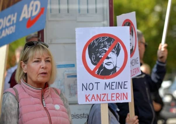 Supporters of the right-wing Alternative for Germany (AfD) political party demonstrate against the German Chancellor and Christian Democrat (CDU) Angela Merkel at a CDU election campaign stop. Picture: Thomas Lohnes/Getty Images