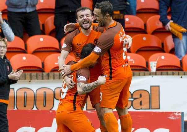 Dundee United's James Keatings (left) celebrates his opening goal with Paul McMullan (centre) and Scott McDonald. Picture: SNS/Paul Devlin