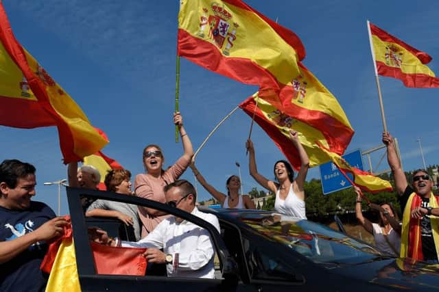 People wave Spanish flags as they gather at Barcelona's port bringing food and drinks to Spanish National Police. Picture: Getty Images