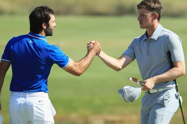 Connor Syme, right, shakes hands with Joel Stalter of France on the 18th green after earning a share of 12th place in Portugal. Picture: Andrew Redington/Getty Images