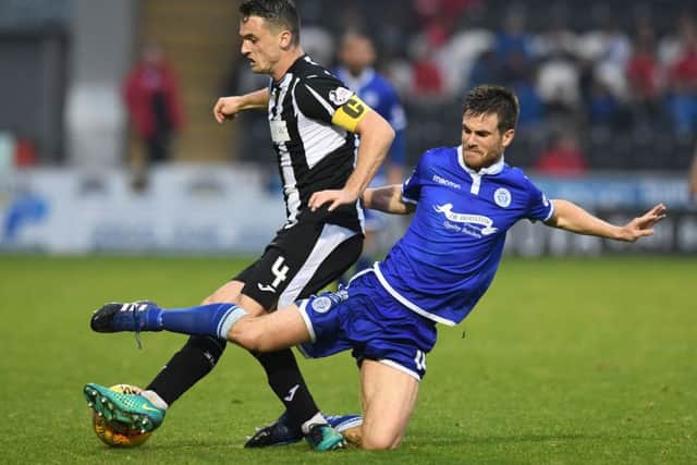 Stephen McGinn of St Mirren resists a strong challenge by Queen of the Souths Kyle Jacobs. Picture: SNS.