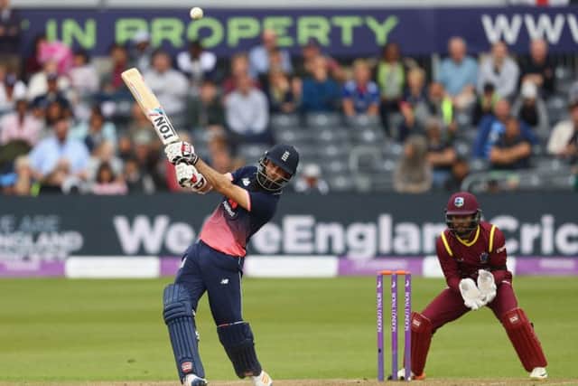 Moeen Ali hits out on his way to making 102 as West Indies wicketkeeper Shai Hope looks on. Picture: Getty