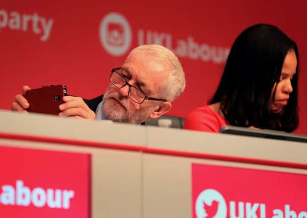 Labour Party leader Jeremy Corbyn takes a photograph as he listens to speeches during their annual conference at the Brighton Centre. Picture: Gareth Fuller/PA Wire
