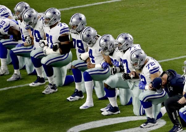 The Dallas Cowboys take a knee prior to the national anthem prior to an NFL football game against the Arizona Cardinals. Picture: AP Photo/Matt York