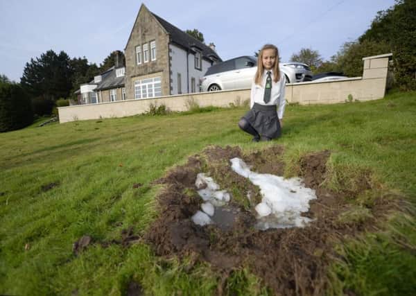 Elise Helliwell, 9, in her garden in Busby, Glasgow, Scotland, where a large block of ice fell out of the sky. Picture: SWNS