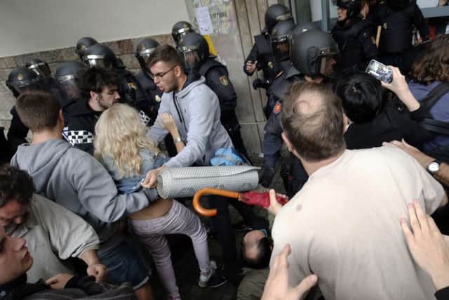 Spanish police officers clash with people at the entrance of a polling station in Barcelona. Picture: AFP/Getty Images