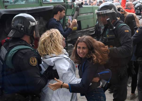 Women clash with Spanish Guardia Civil guards outside a polling station in Sarria de Ter, where the Catalan president is supposed to vote. Picture: AFP/Getty Images