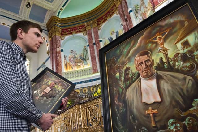 PhD student Michael Connolly inspecting a Peter Howson painting of Celtic FC founder Brother Walfrid in St Mary's Church in Calton. Picture: PA