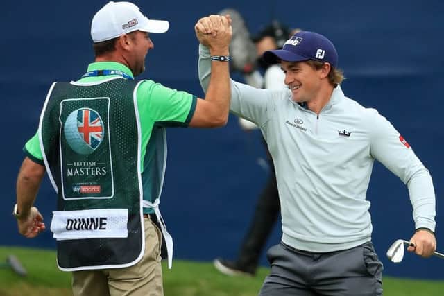 Paul Dunne celebrates with his caddie Darren Reynolds after chipping in on the 18th hole to win the British Masters at Close House. Picture: Andrew Redington/Getty Images