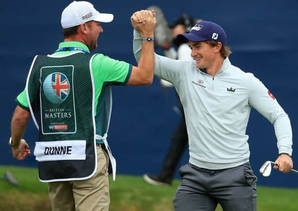 Paul Dunne celebrates with his caddie Darren Reynolds after chipping in on the 18th hole to win the British Masters at Close House. Picture: Andrew Redington/Getty Images