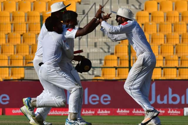 Sri Lankas Rangana Herath, right, celebrates with team-mates after their win on the fifth day of the first Test against Pakistan. Picture: Getty