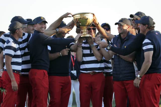 The U.S. Team celebrates with the winner's trophy after the final round of the Presidents Cup golf tournament at Liberty National Golf Club in Jersey City, N.J., Sunday, Oct. 1, 2017. (AP Photo/Julio Cortez)