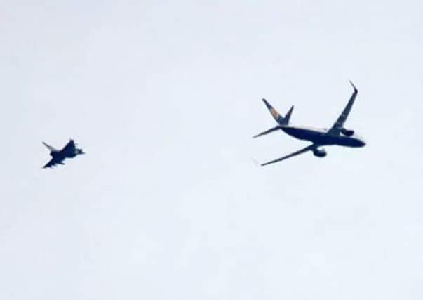 A RAF Typhoon jet escorting the  Ryanair passenger jet into Stansted airport this morning. Picture: SWNS