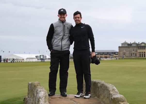 Connor Syme with Rory McIlroy on the Swilcan Bridge in St Andrews. Picture: Ross Kinnaird/Getty Images