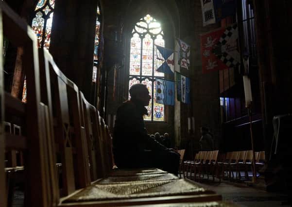 A worshipper in St Giles' Cathedral, Edinburgh. Photograph: Neil Hanna