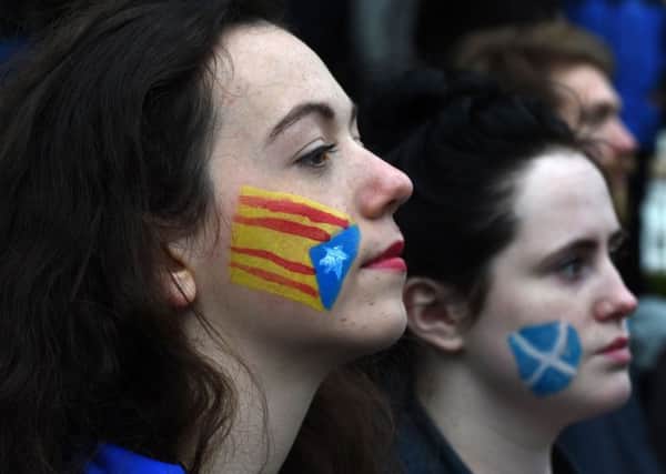 Demonstrators have the Catalan Flag, the Senyera (L) and the Flag of Scotland, the Saltire (R) painted on their faces during a protest to show solidarity with Catalonia, in central Glasgow. Picture: ANDY BUCHANAN/AFP/Getty Images