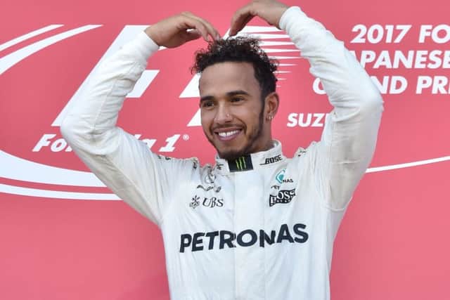 Athlete Mo Farah was a guest of Lewis Hamilton and Mercedes in Japan so Hamilton did the 'Mobot' on the podium. Picture: AFP/Getty Images