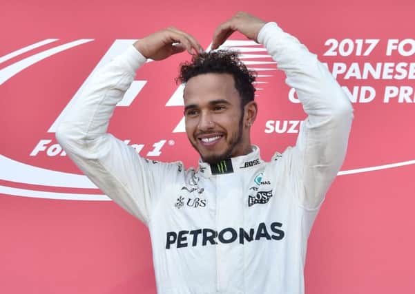 Athlete Mo Farah was a guest of Lewis Hamilton and Mercedes in Japan so Hamilton did the 'Mobot' on the podium. Picture: AFP/Getty Images