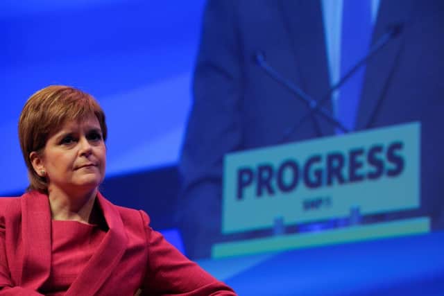 Nicola Sturgeon listens to the address of Deputy First Minister John Swinney on the opening day of the SNP annual conference in Glasgow. Picture: AFP
