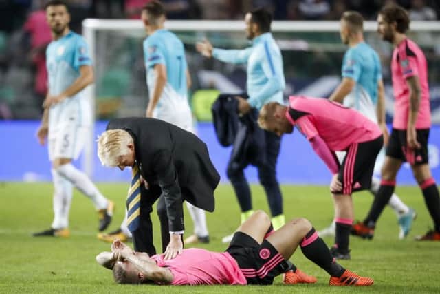 Gordon Strachan comforts striker Leigh Griffiths after the draw against Slovenia ended Scotland's hopes of securing a place in the World Cup play-offs. Picture: Getty Images