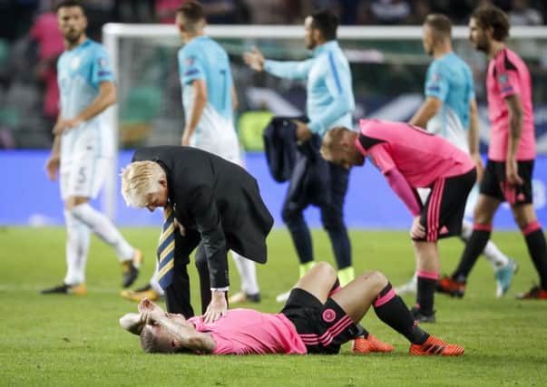 Gordon Strachan comforts striker Leigh Griffiths after the draw against Slovenia ended Scotland's hopes of securing a place in the World Cup play-offs. Picture: Getty Images